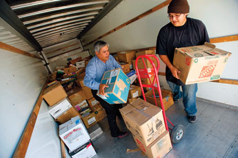 Irving Nelson, left, the program supervisor for the Navajo Nation Museum and Library, and Daven Klade unload books from a truck on Monday morning. The museum received more than 15,000 books in the form of a donation from the Reader to Reader program. © 2011 Gallup Independent / Brian Leddy 